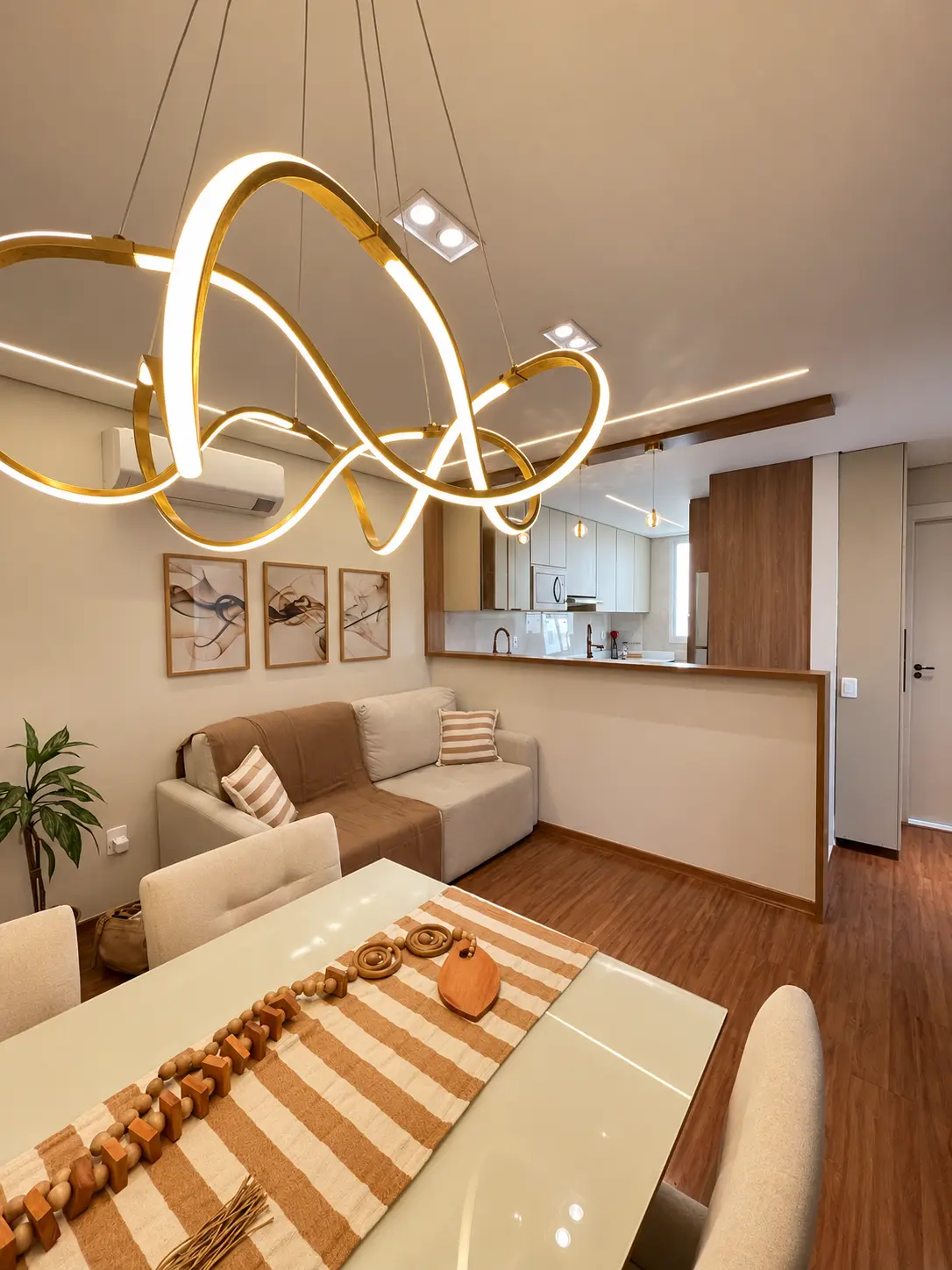 Sala de estar e jantar integrada com lustre escultural dourado