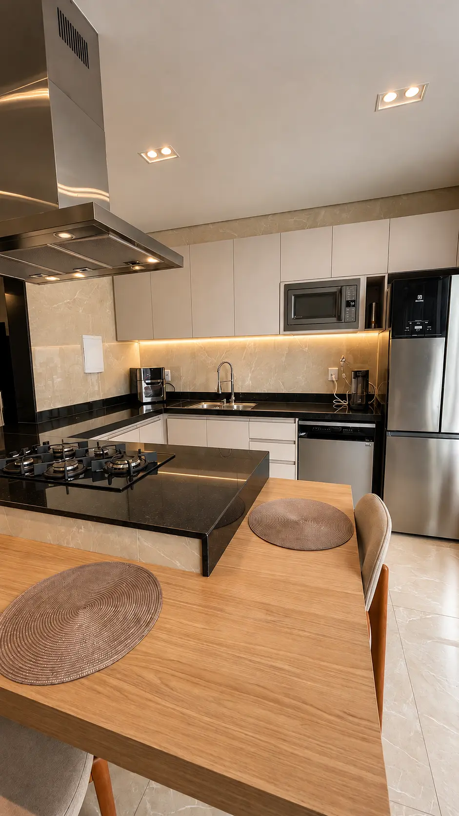 Cozinha gourmet com ilha preta e eletrodomésticos em inox